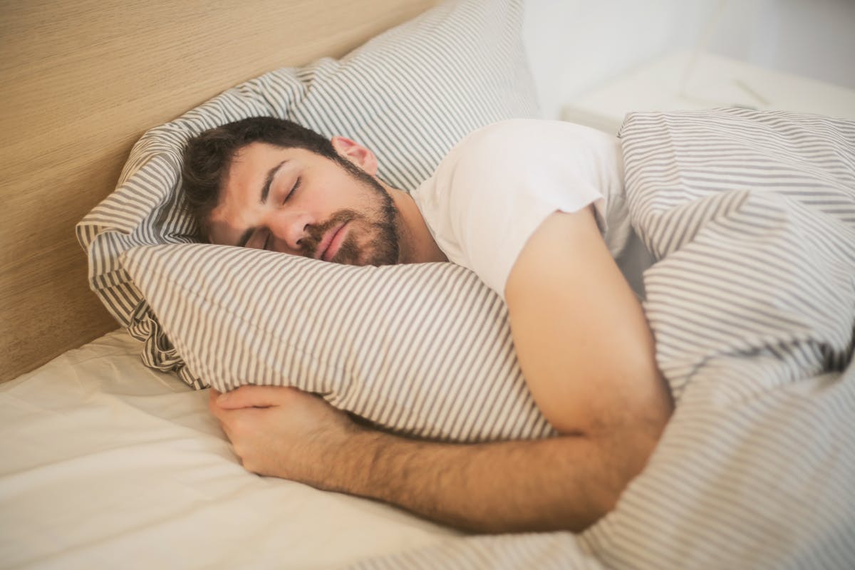 Chambre épurée avec literie blanche en lumière douce du matin