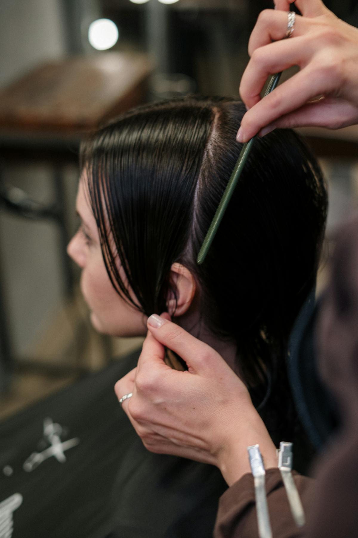 Femme appliquant de la coloration sur ses cheveux avec un pinceau, cheveux divisés en mèches