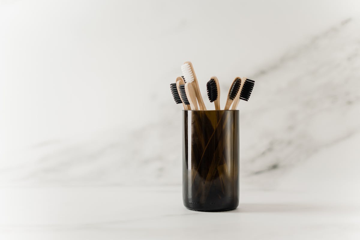 Bol de masque capillaire crème avec fleurs séchées sur fond bois