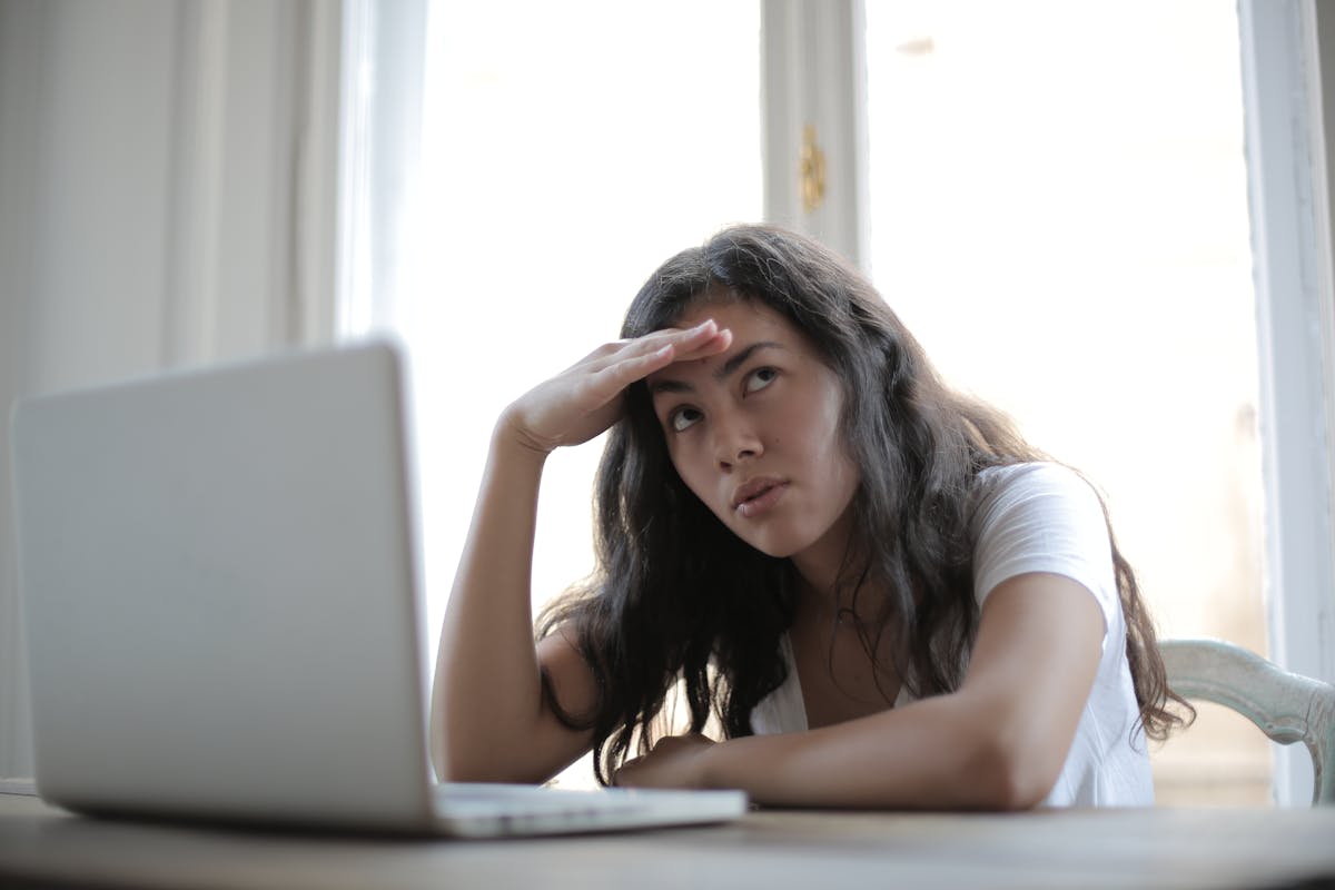 Femme les mains sur les tempes, regard concentré, lumière naturelle douce