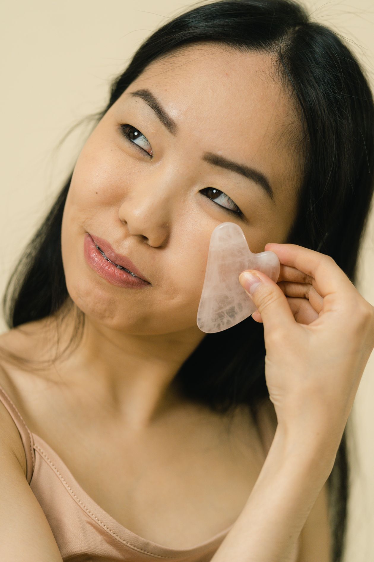 Pierre gua sha en jade verte sur fond blanc avec fleurs