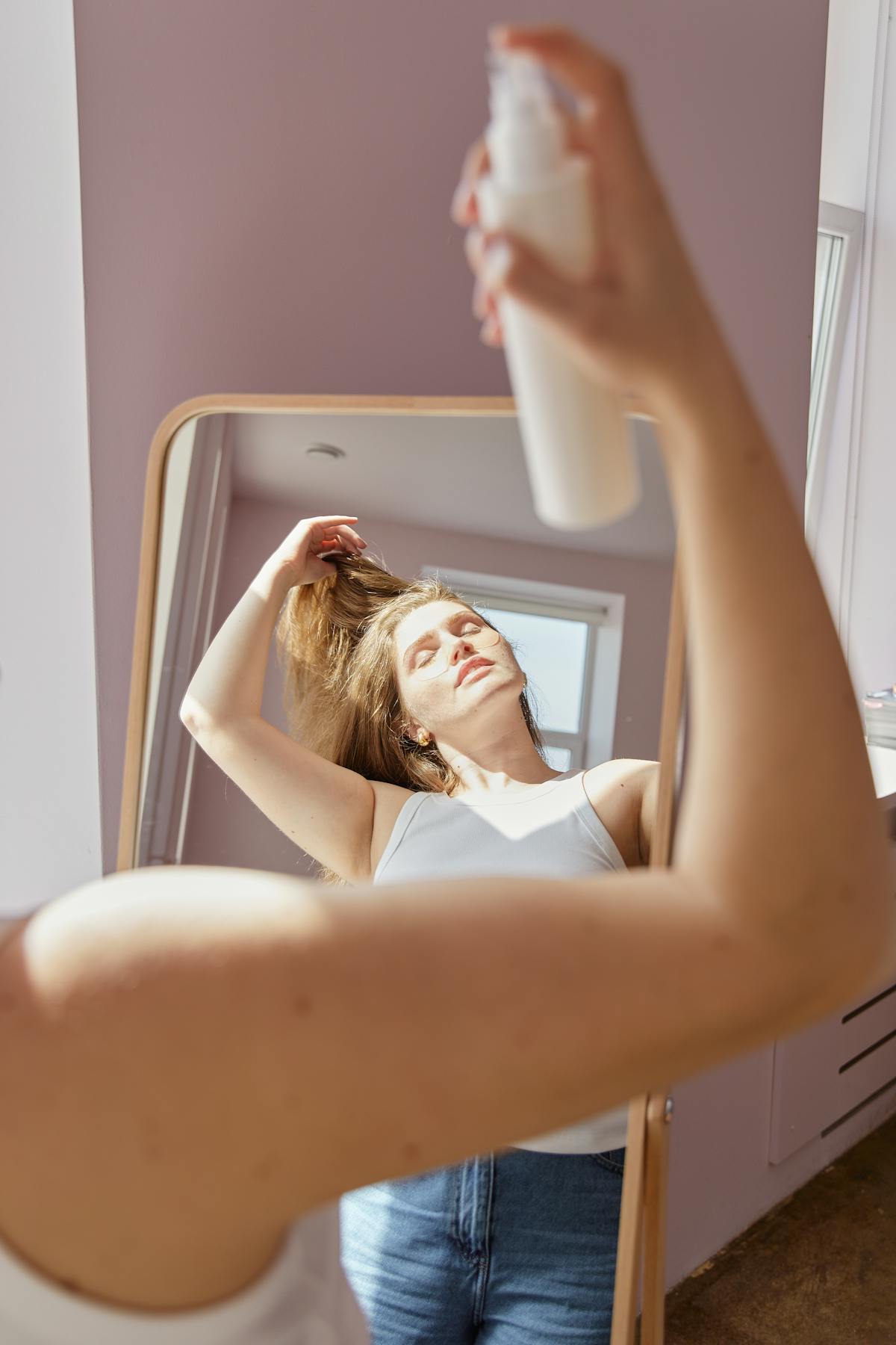 Produits capillaires alignés sur une étagère de salle de bain, fond clair