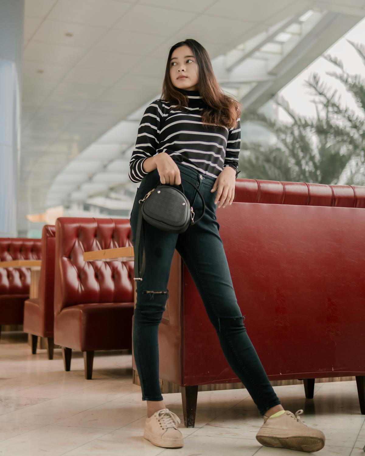 Femme portant un sac bandoulière en cuir dans un style élégant en ville